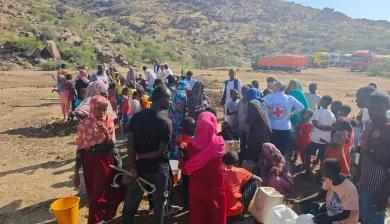 ICRC staff assist displaced families gathering for aid distribution in a rural, mountainous area, in Port Sudan.